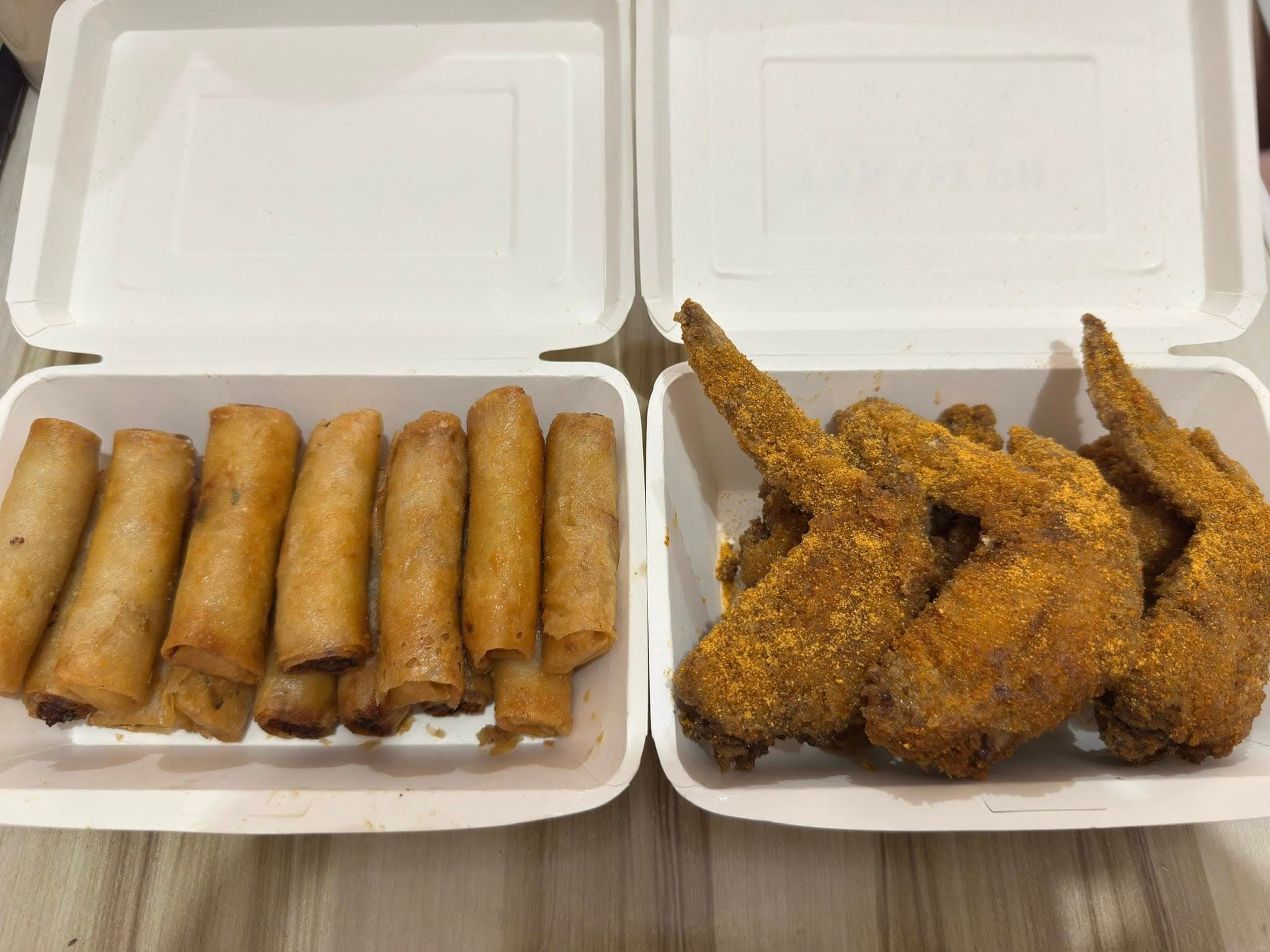 Takam PH lumpia and wings in takeout boxes.