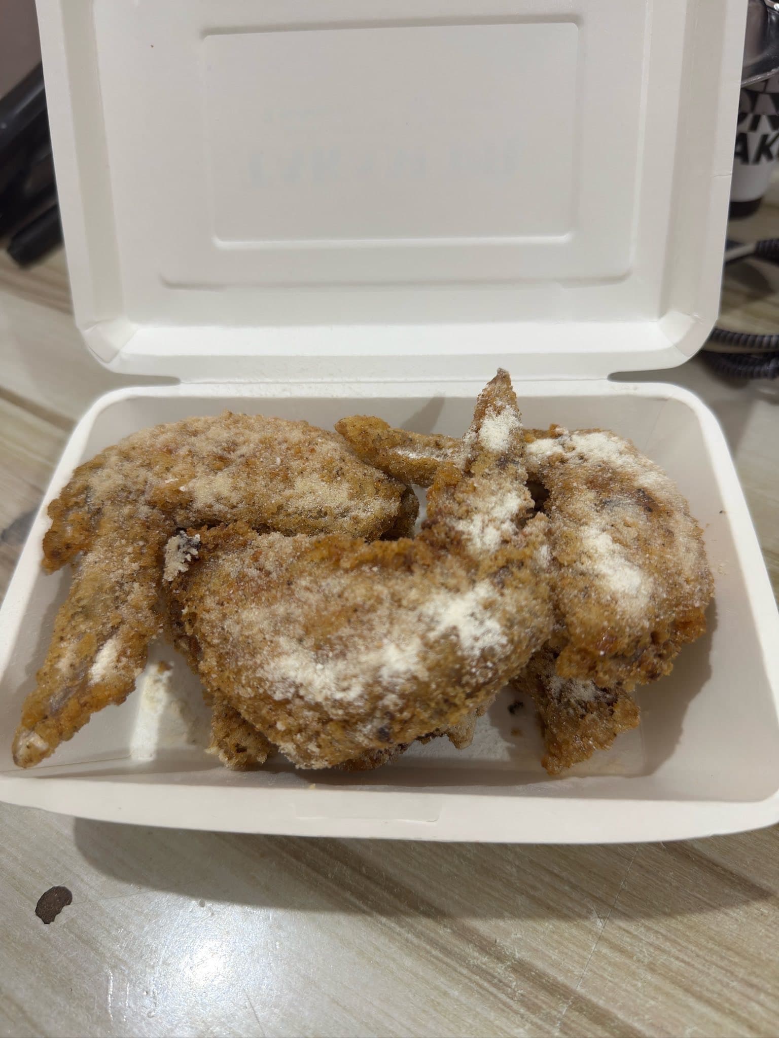 Takam PH powdered wings in a takeout box.