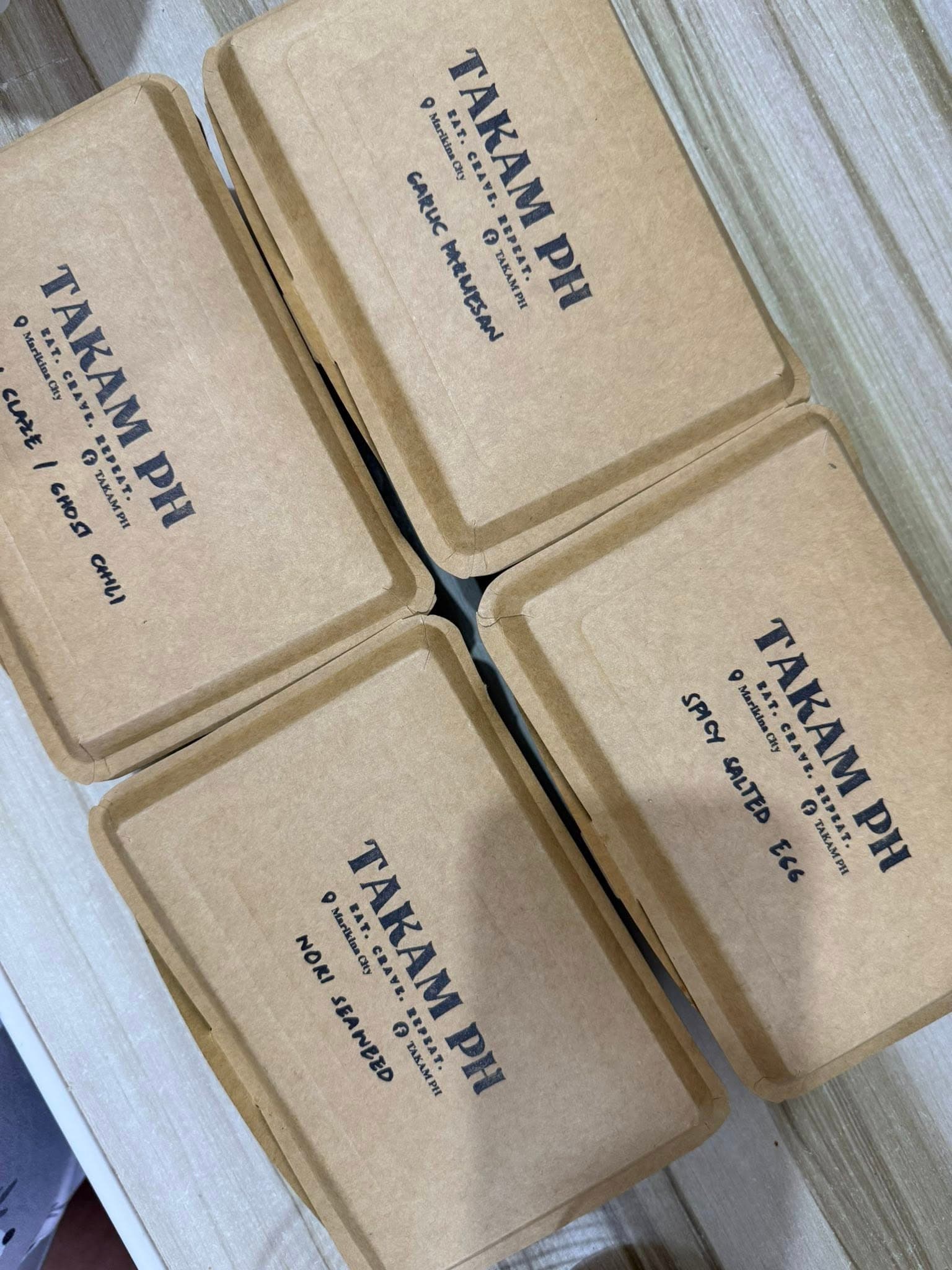 Takam PH branded takeout boxes with handwritten flavor labels.